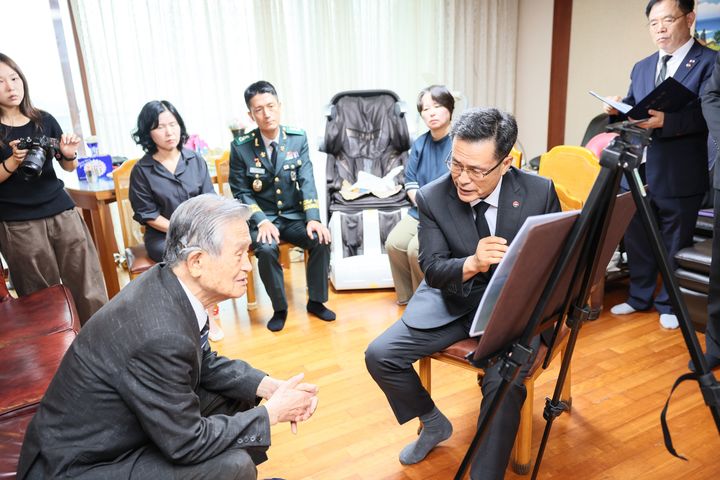 전병희 국방부 유해발굴감식단장이 김하준 옹에게 발굴 및 신원확인 과정을 설명하는 모습