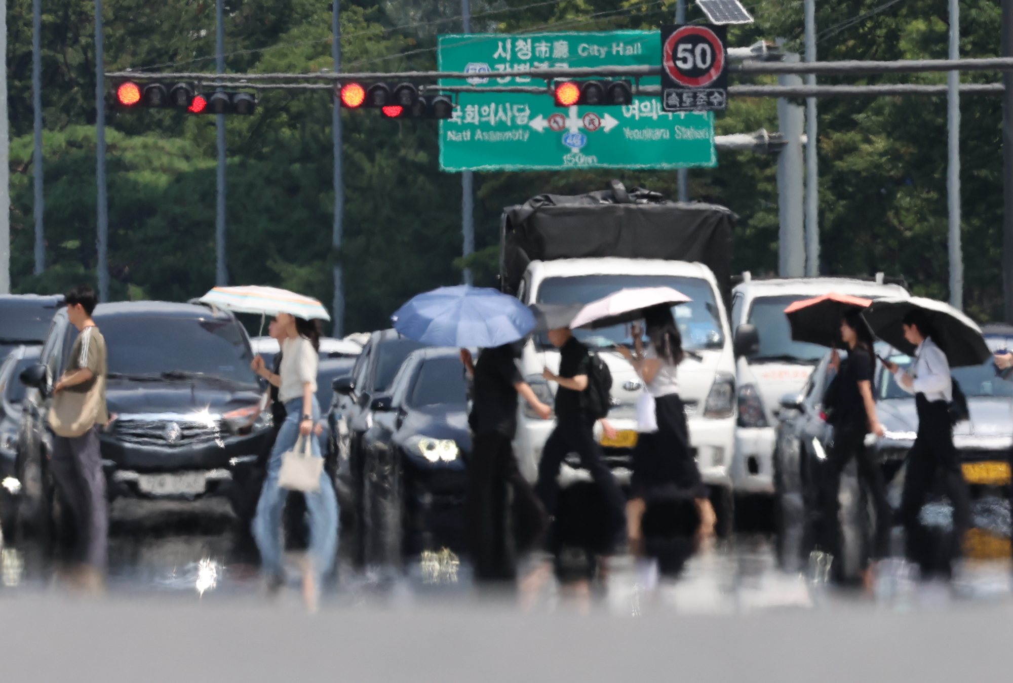 폭염 속 우산을 쓰고 횡단보도를 건너는 시민들